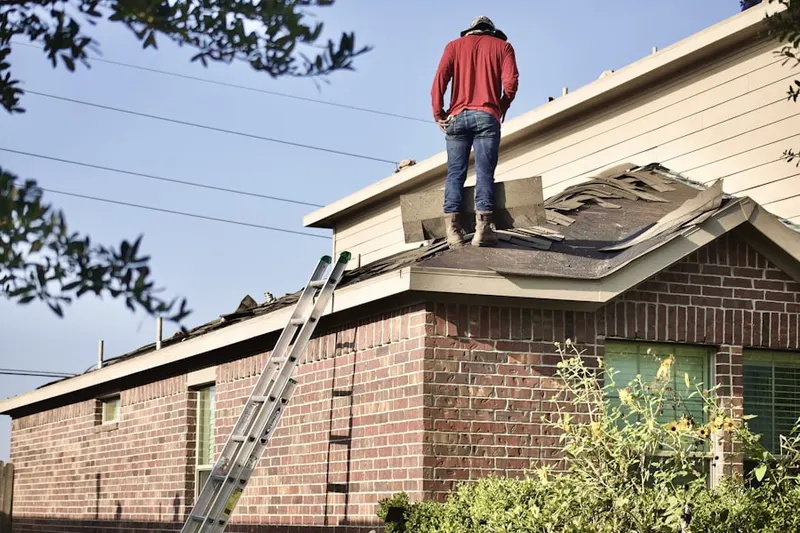 Professional roofer working on a residential roof in Bedford Center